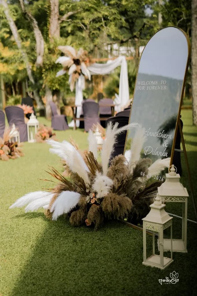 Garden welcome setup with pampas grass, lanterns and a mirrored welcome board